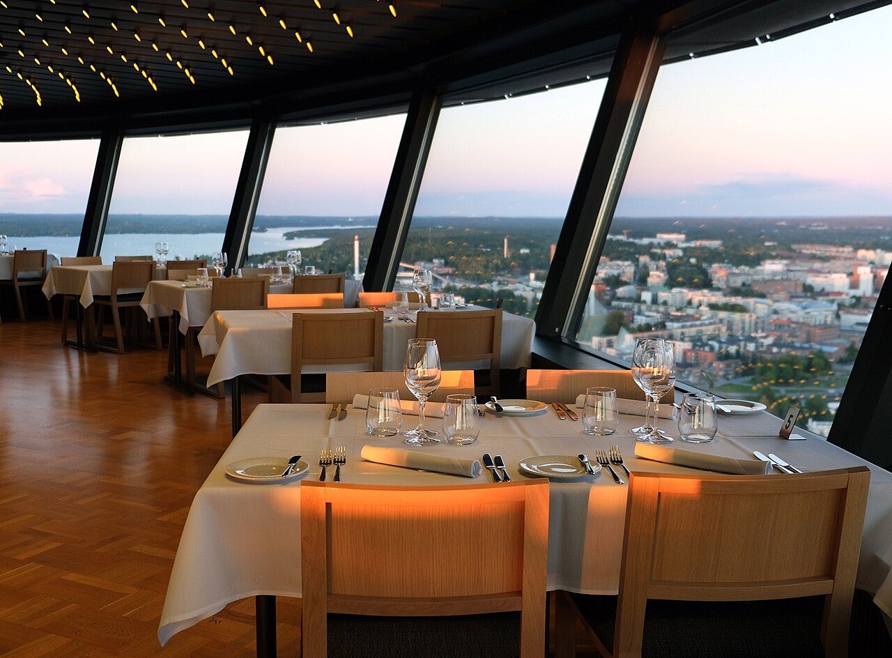 Tables set at sunset by the panoramic windows